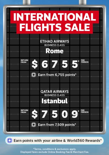 Airport departure board featuring return business class flights to Rome from $6,755 and Istanbul from $7,509