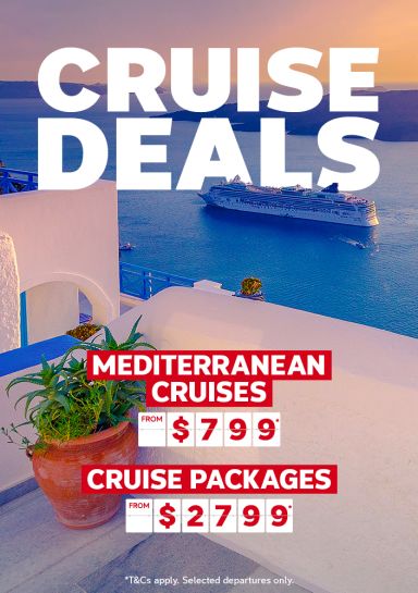 Cruise ship sailing past Santorini in the early evening featuring cruise deals like Mediterranean cruises from $799 and cruise packages from $2,799