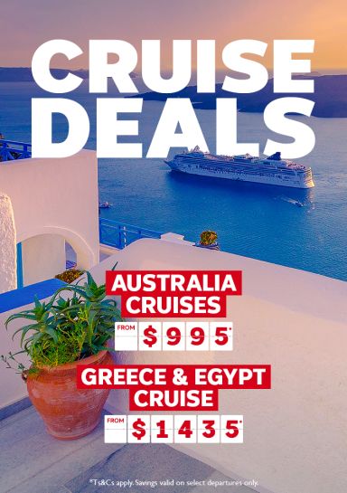 Cruise ship sailing past Santorini in the late afternoon featuring cruise deals