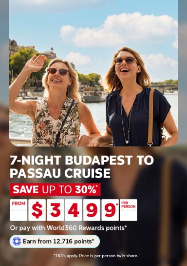Two friends laughing on a river cruise deck along a European waterfront for a 7 night Budapest to Passau cruise saving up to 30 percent from 3499