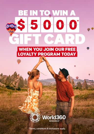 Couple dancing beneath hot air balloons over a scenic valley featuring a chance to win a $5000 gift card when you join our free loyalty program