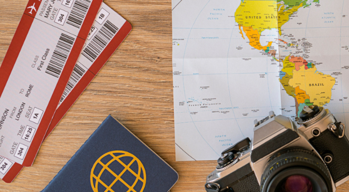 A map, camera, plane tickets and passport on a table