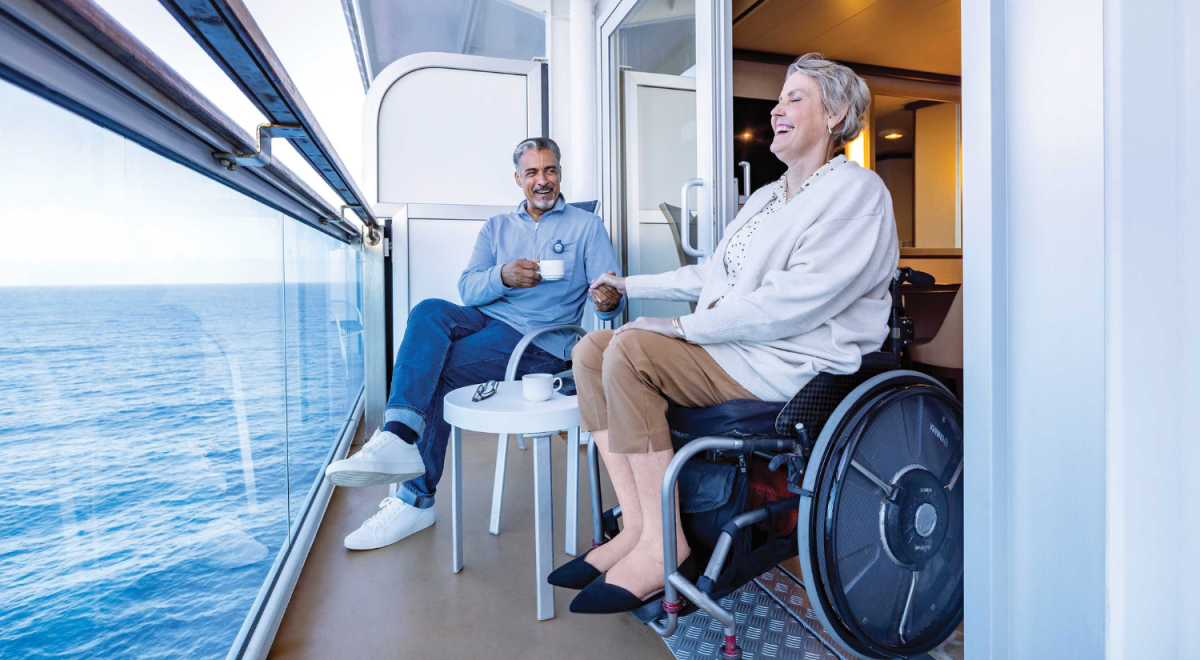 A woman using a wheel chair enjoy time on a ship's balcony with her partner.