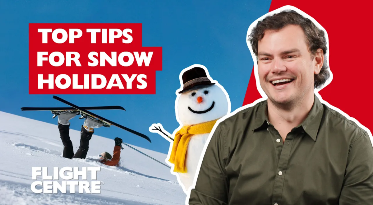 Man sitting next to snowman with person in the snow