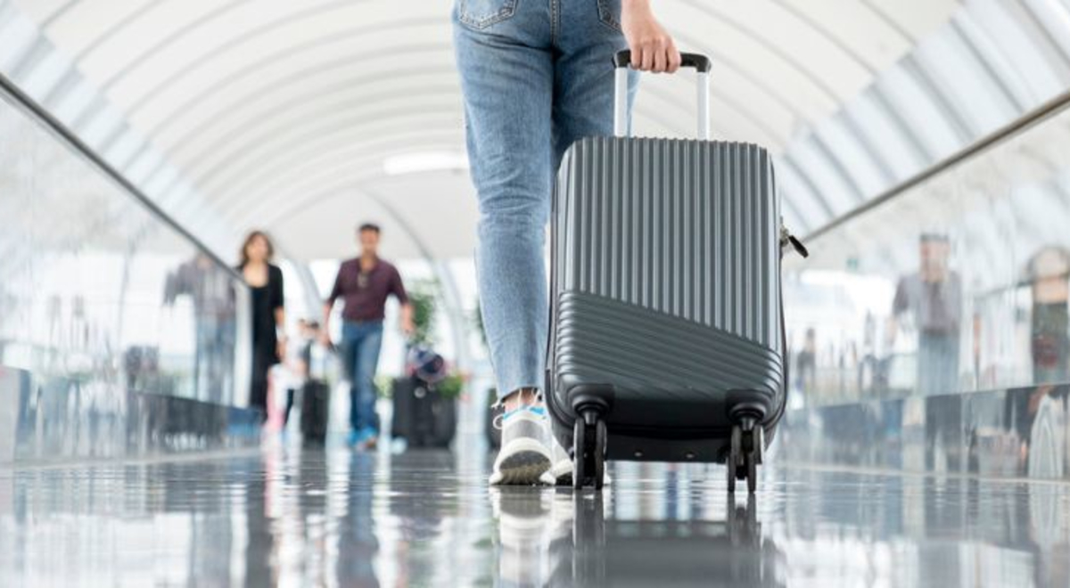 Image of a suitcase being wheeled through airport