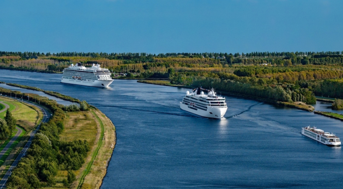 Viking Polaris, Venus and Mani cruise ships sailing in convoy along a wide canal near Amsterdam