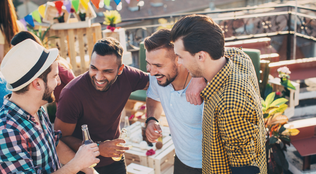four men standing together and laughing on rooftop