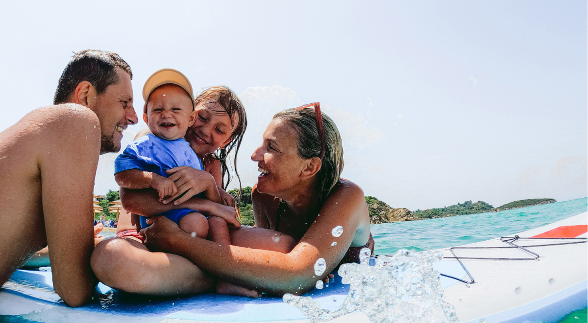 Parents and their two young children floating on a paddleboard