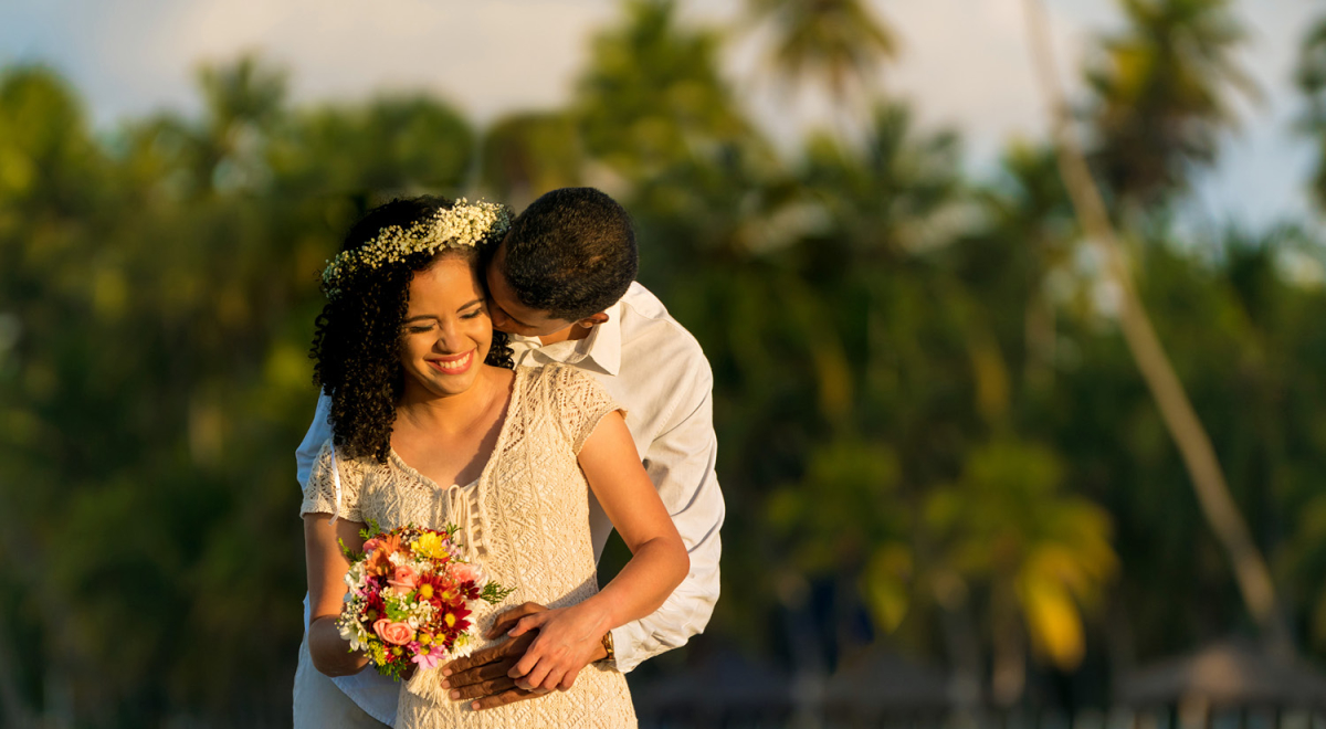 A couple poses for a photo during their destination wedding