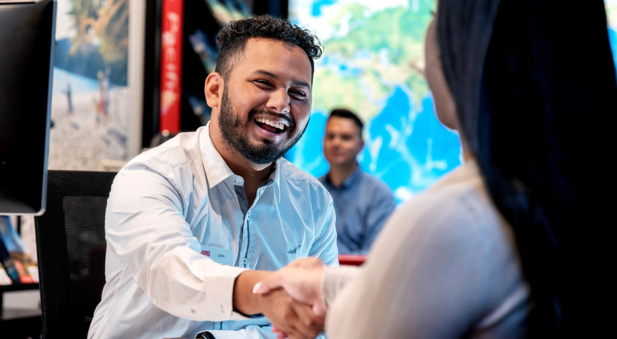 A Flight Centre travel consultant working with a client in store