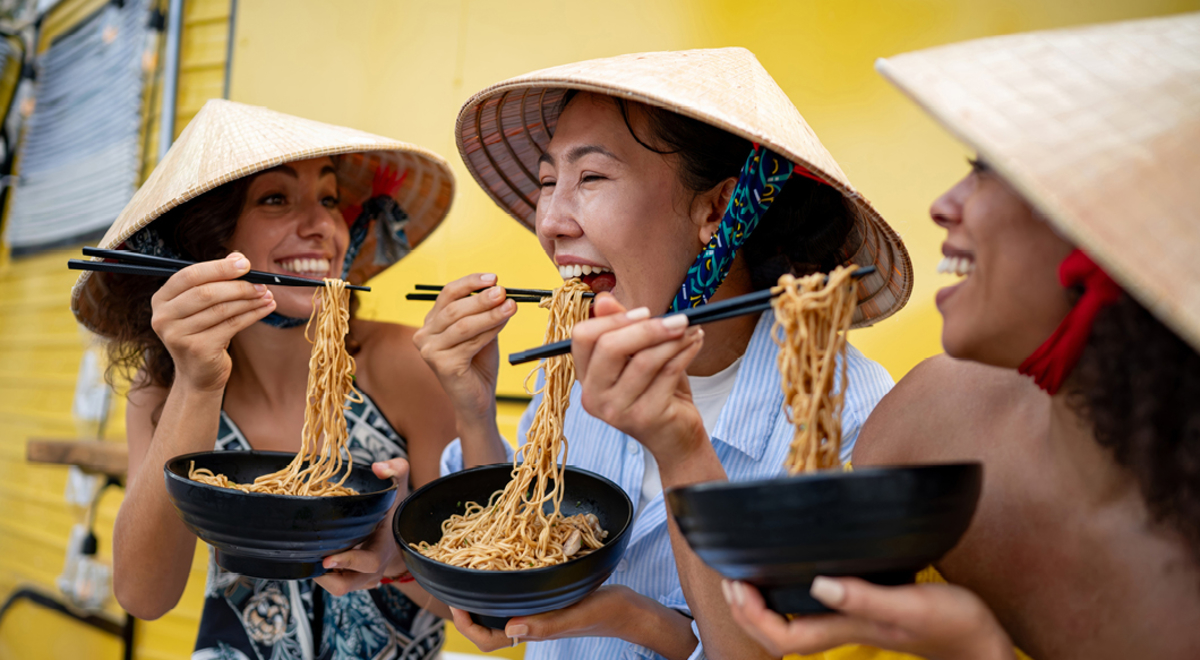 Travellers eating noodles while on a food tour in Asia