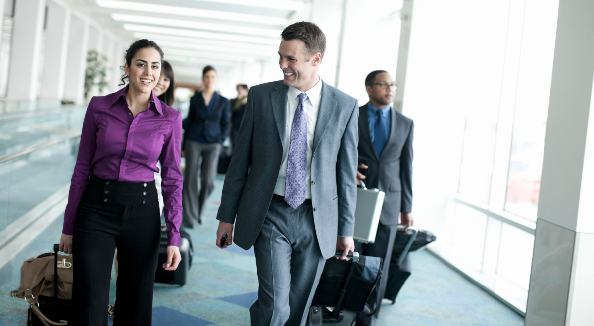 Airport with Business Team Walking, Pulling Luggage and Smiling