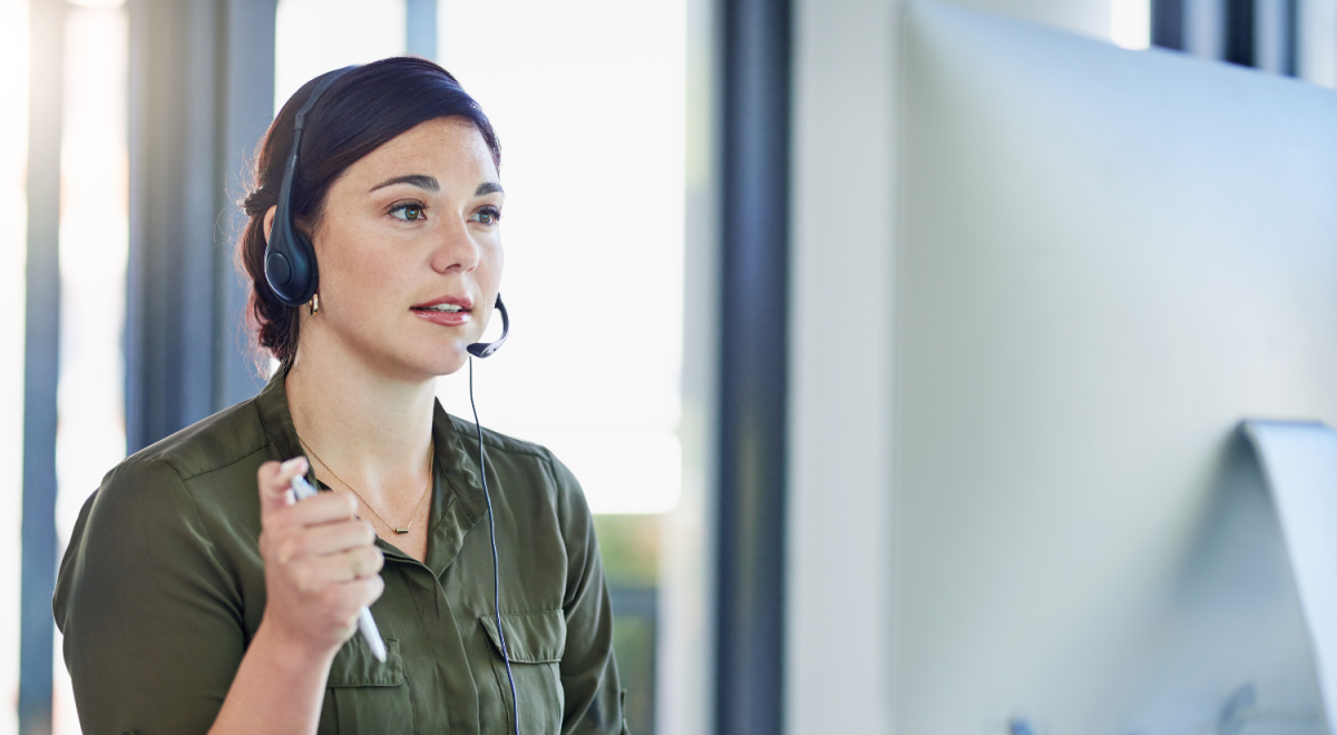 A woman wearing a headset talks with a customer