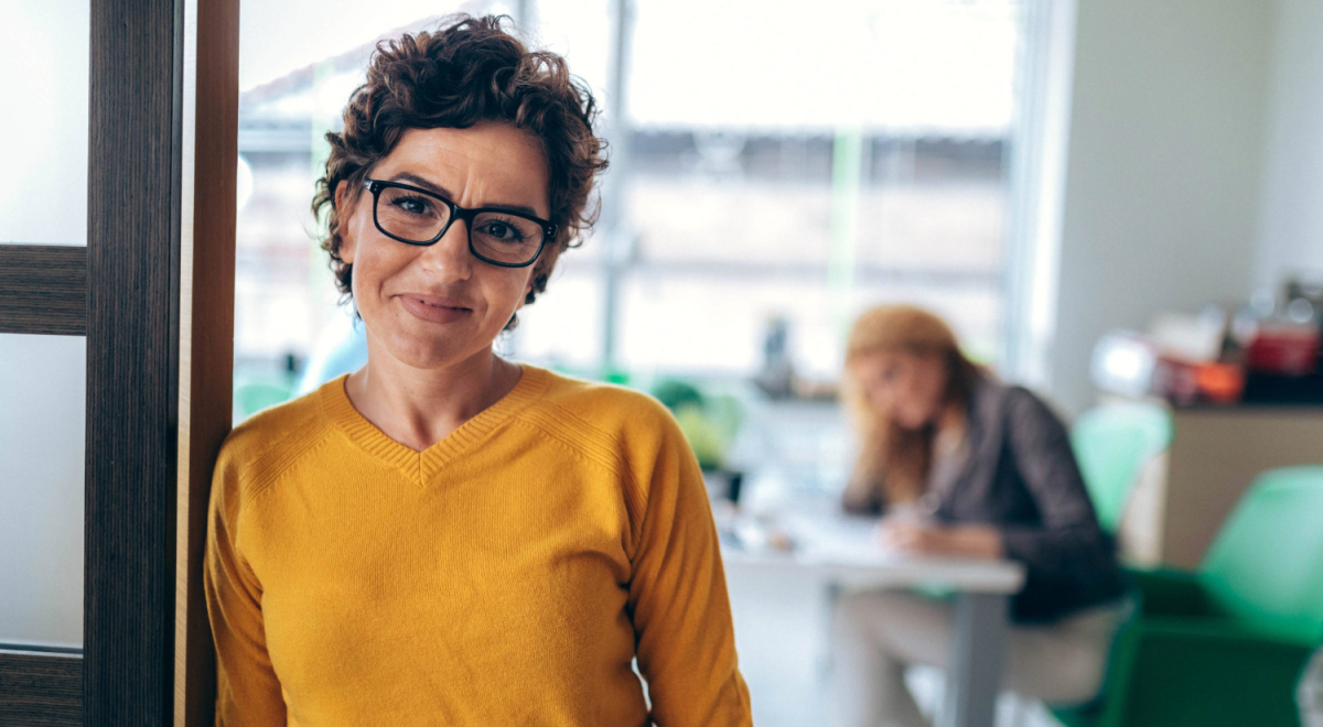 A woman stands in the doorway of an office
