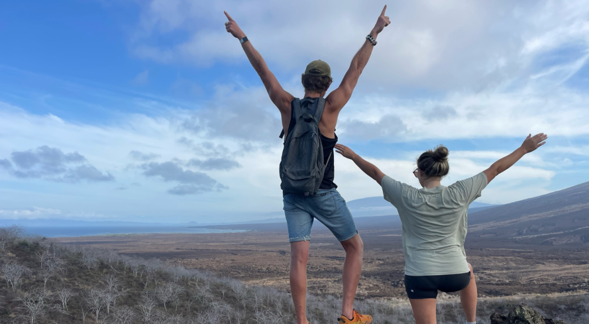A couple looks out over the Galapagos Islands landscape.