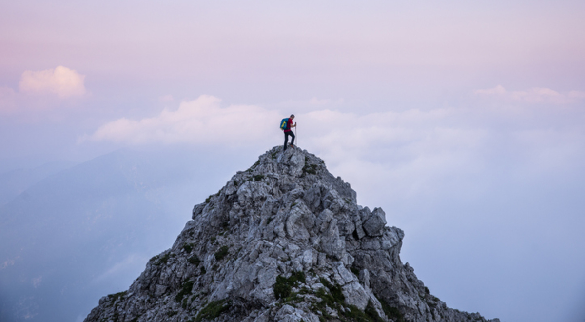 Hiker man on the top of mountain during twilight