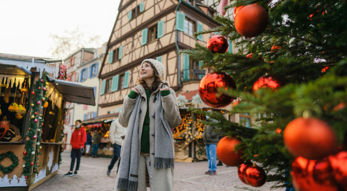A young person walking through a town that's decorated for Christmas