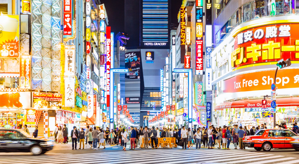 Shibuya Crossing in Tokyo crowded and lit bright at night.