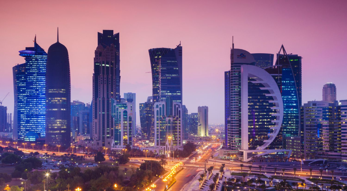 The Qatar skyline at dusk. The sky has turned a stunning deep maroon colour as the sun sets