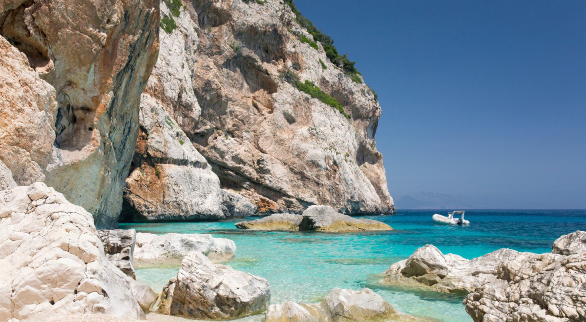 A tall sandstone rising out of clear blue water