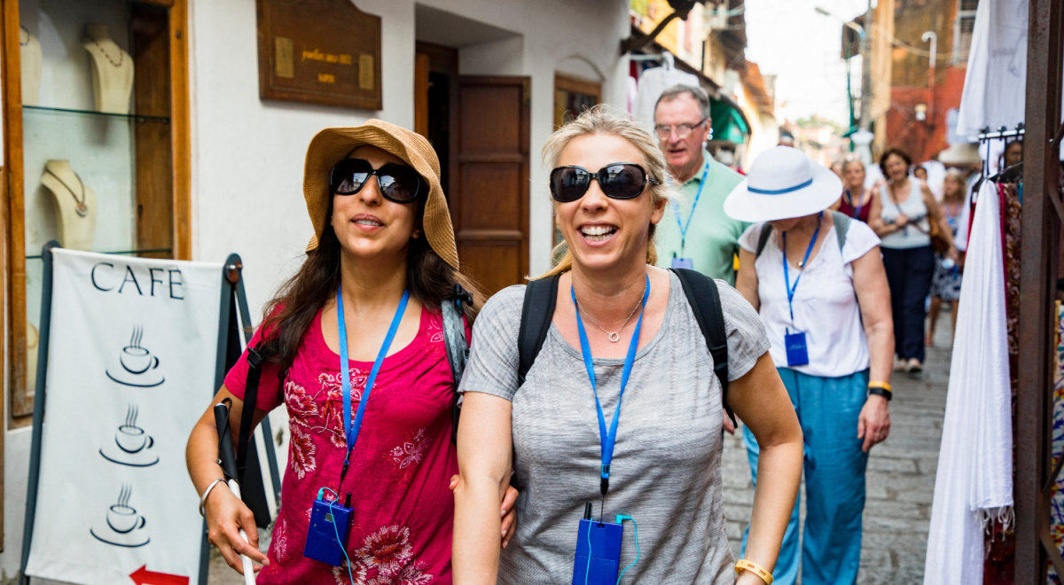 Two tourists smiling walking down street