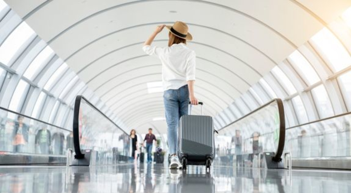 Image of a suitcase being wheeled through airport