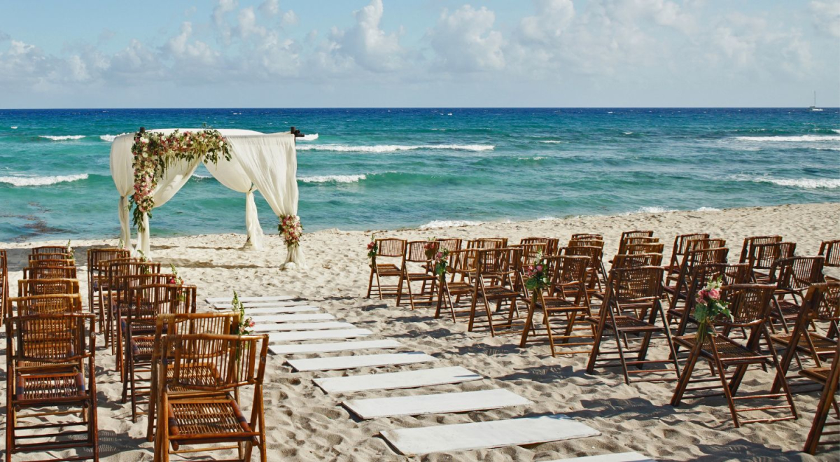 wedding on beach with wooden chairs
