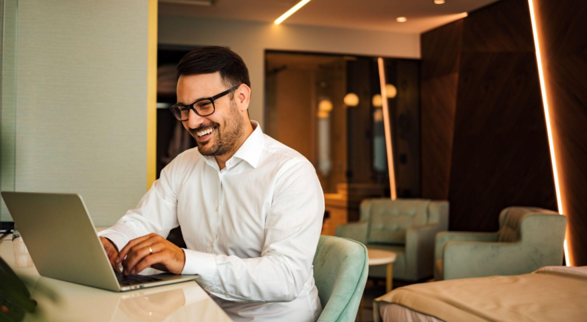 man typing on laptop while smiling 