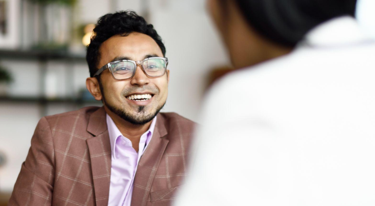 person smiling at person across table 
