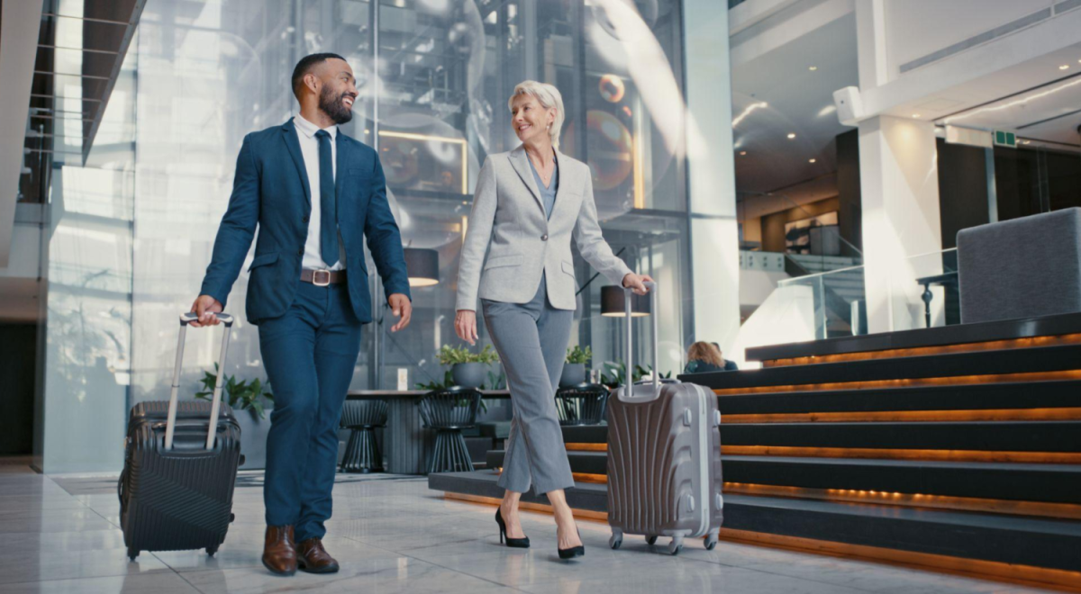 Man and lady pulling suitcases through building