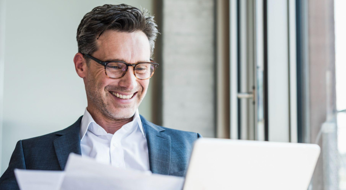Business man looking at laptop and smiling