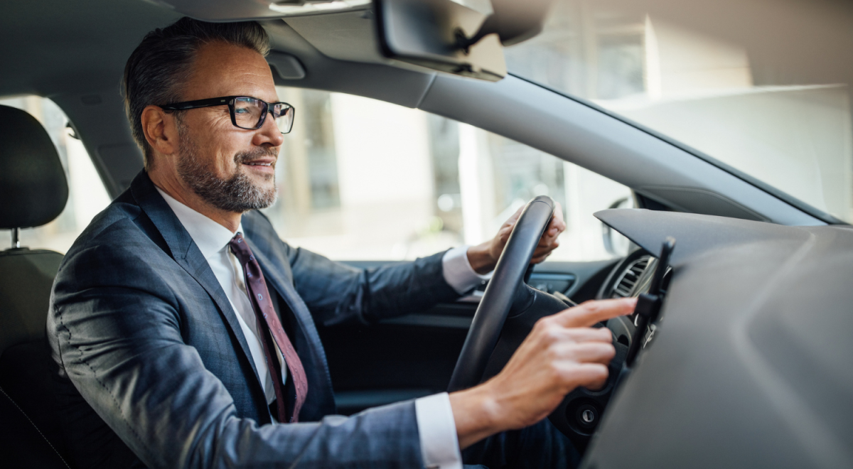 A man in a business suit driving a car