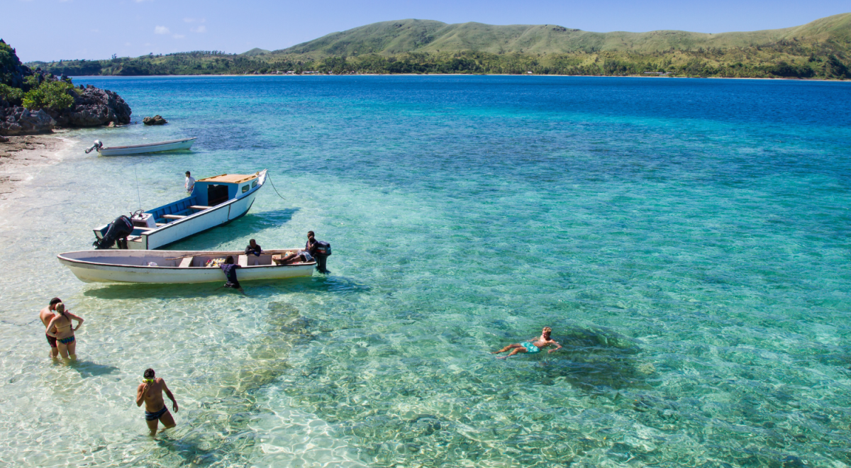 boat and people on the shore of fiji 