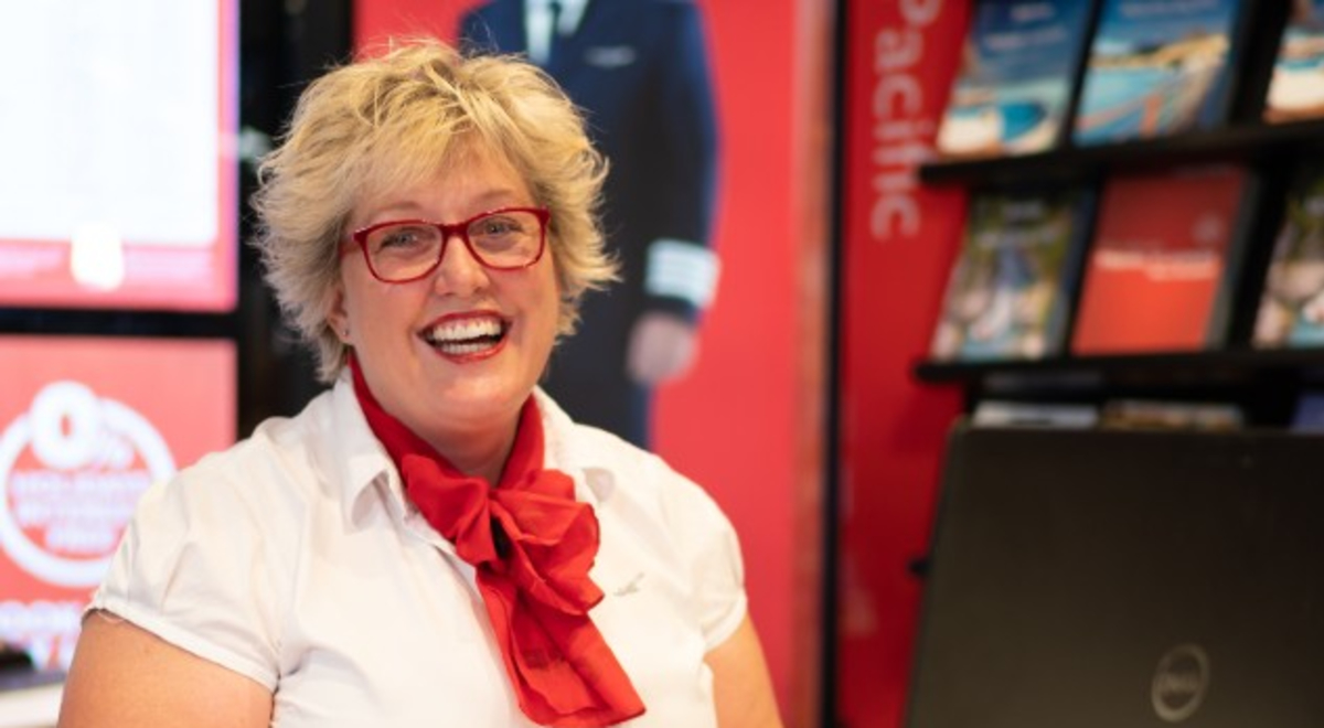 Travel agent smiling sitting at desk in store
