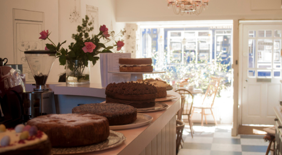 A beautiful cafe with assorted types of cake on the counter