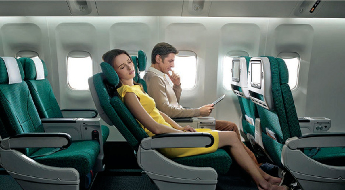 Lady relaxes with her seat reclined while a man reads next to her in flight