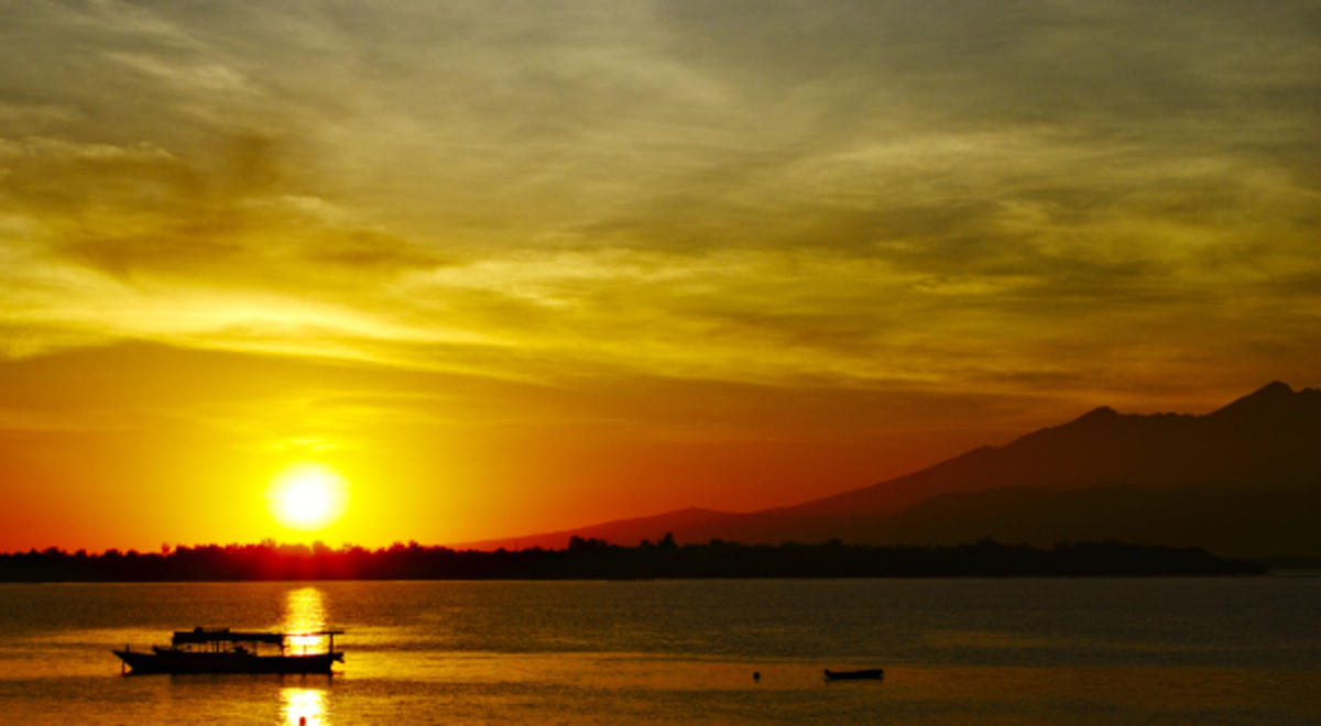 Sunrise with boat and mountains