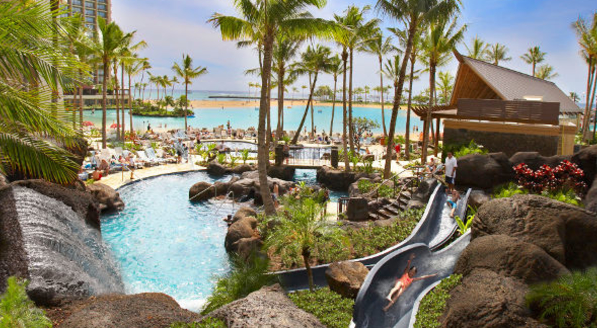Luxurious pool area with tourists enjoying the slide