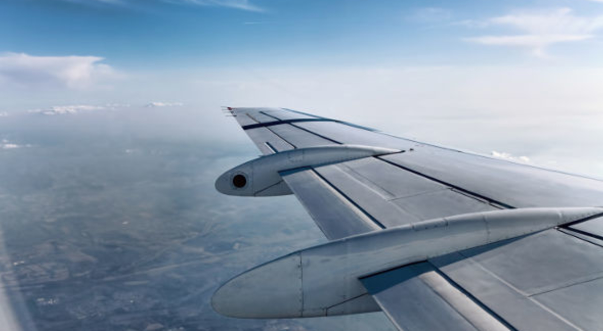 Airplane's left wing soaring through the sky
