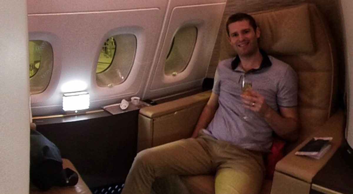 Couple holding a glass of champagne in their business class seat