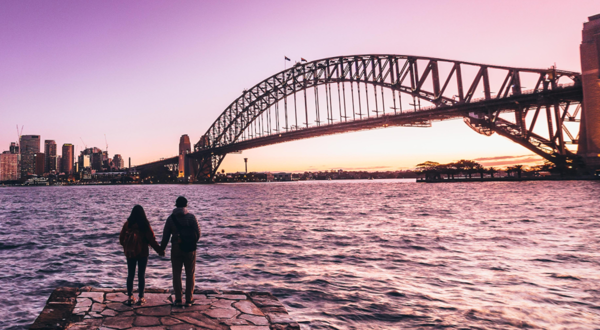 Two tourists watching the sunset over the lake and the city view