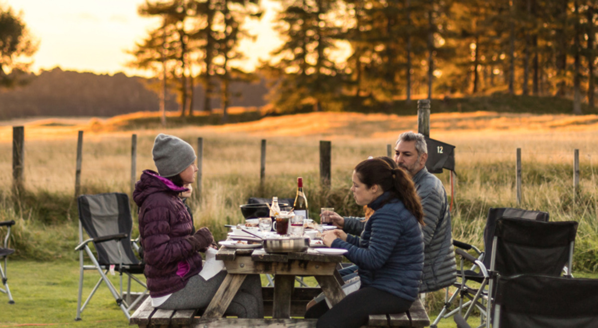 Group sharing dinner next to their caravans 