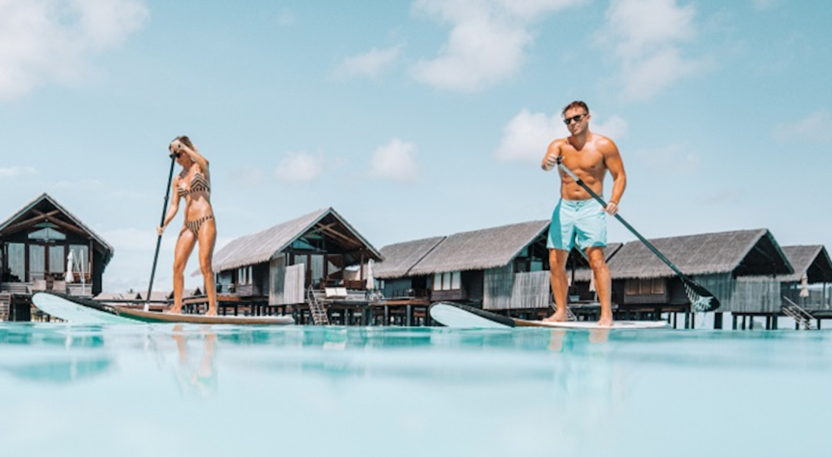 A couple paddle boarding in the ocean 