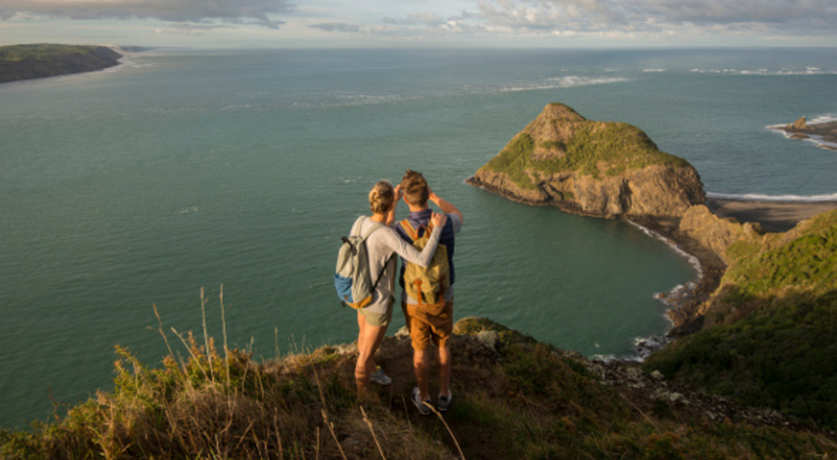 A couple on the edge of the hill in beach whatipu