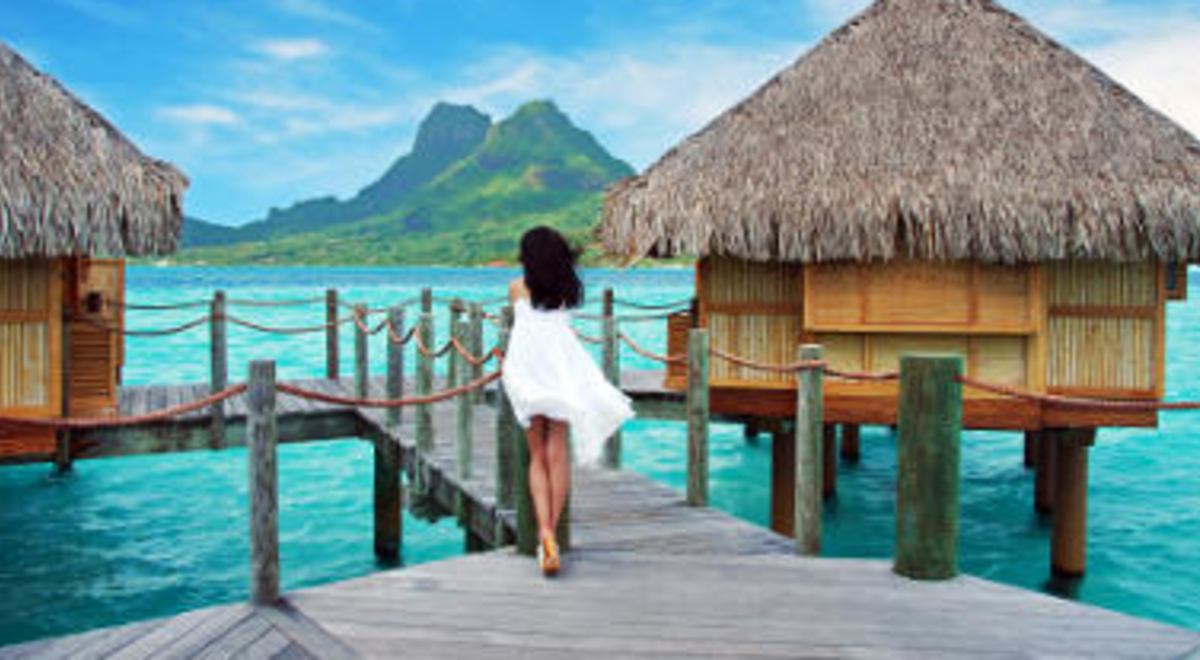 Woman walking on the overwater path in Bora Bora 
