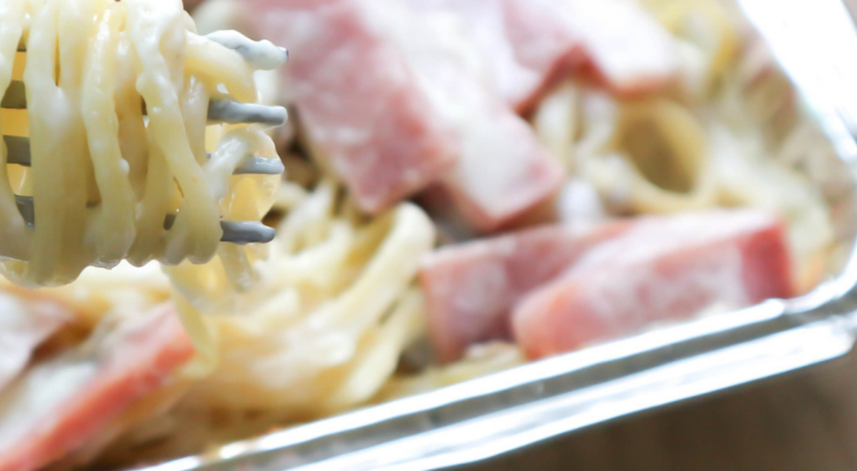 Close-up shot of spaghetti carbonara in a tin container