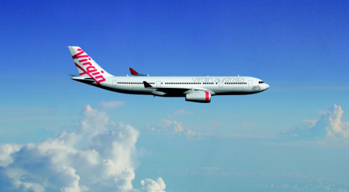 Virgin Australia plane flying in the blue sky with white  cotton-like clouds on the backgroundn 
