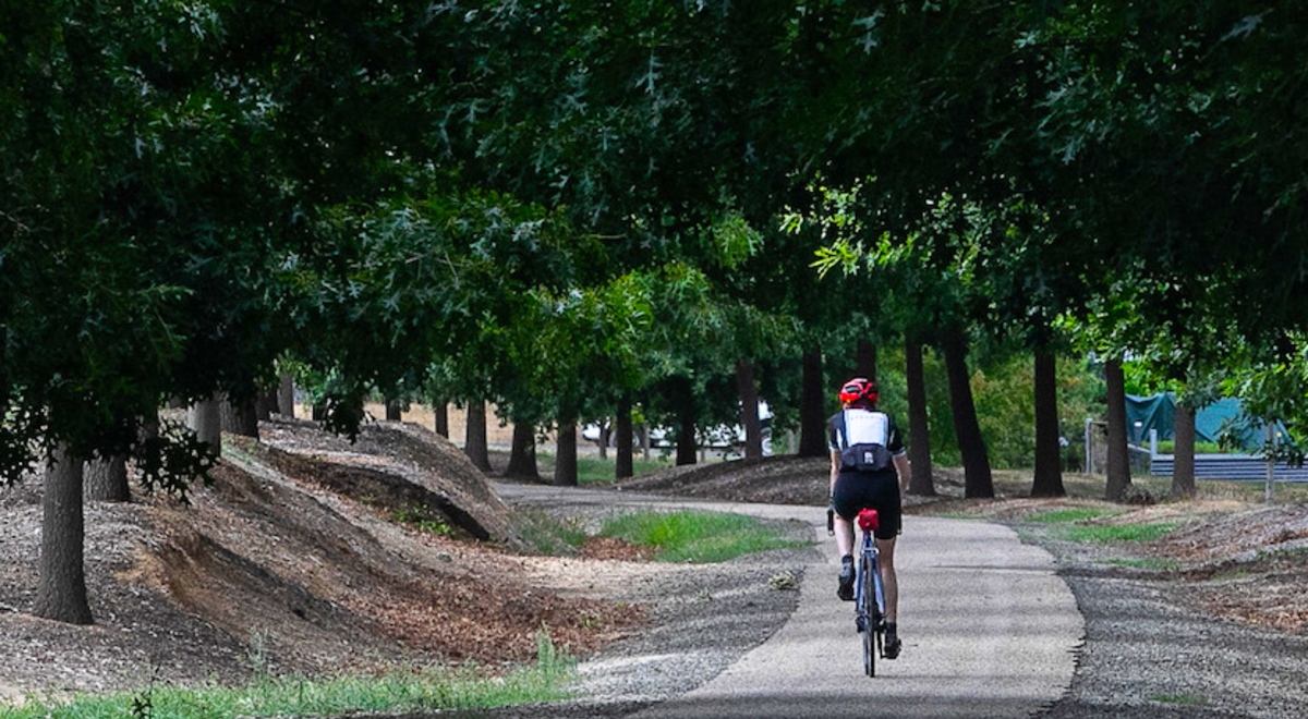 A lady riding her bike around the park