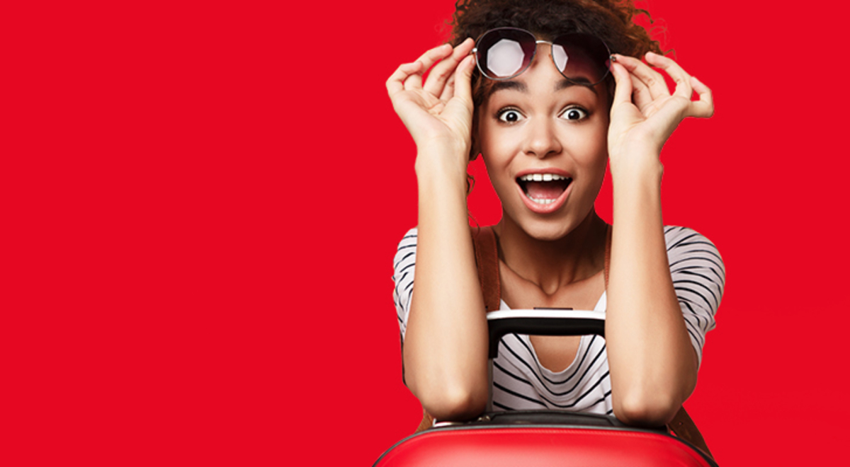 a surprised looking curly woman with a red luggage