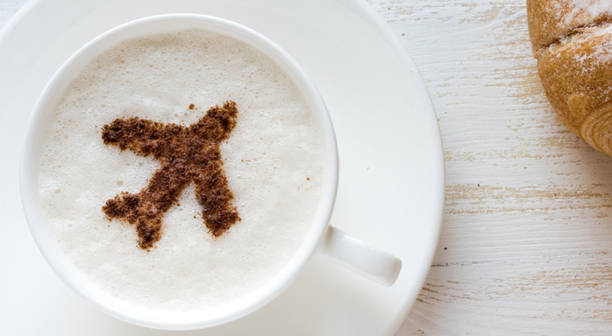 Croissants next to a latte art with airplane design